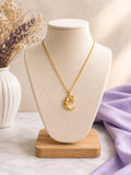 Gold crescent moon and star face pendant necklace on a bust stand