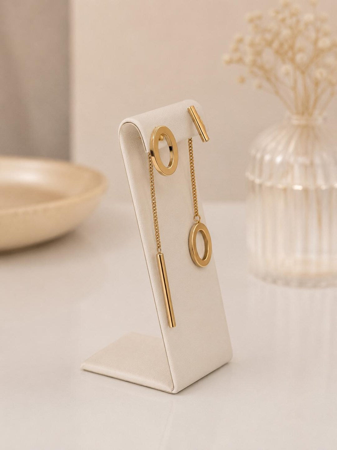Asymmetrical earrings on display stand